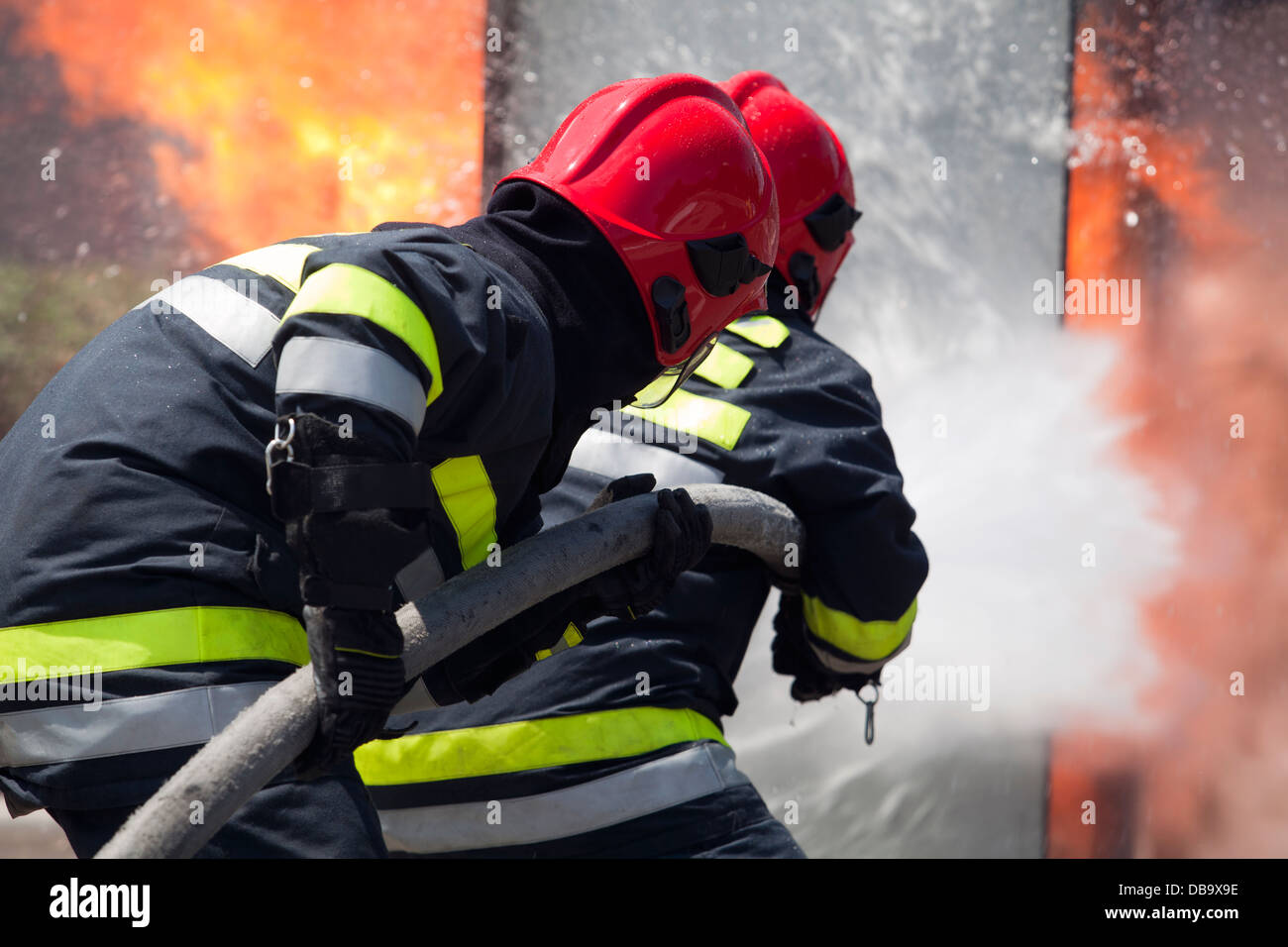 firefighters fighting fire Stock Photo