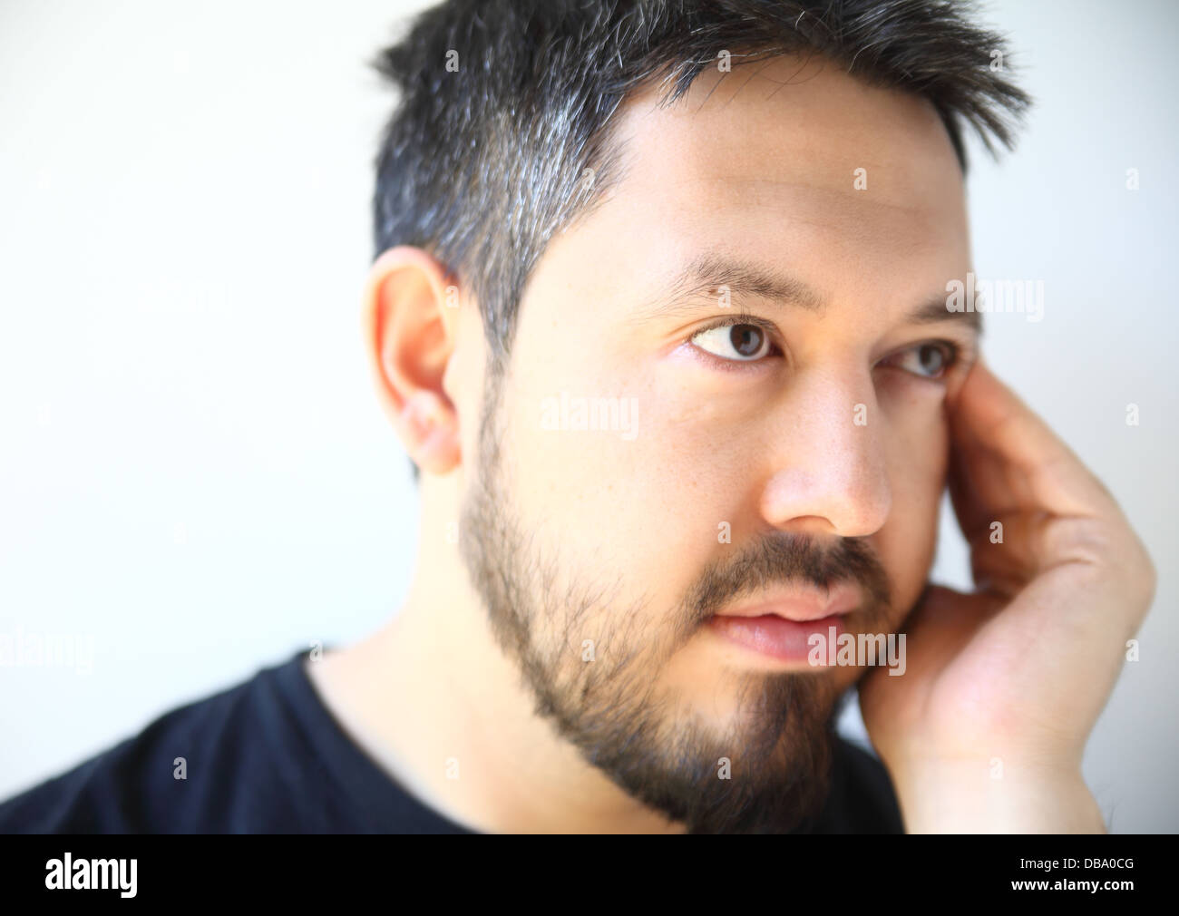bearded thirty-something man with a pensive expression Stock Photo
