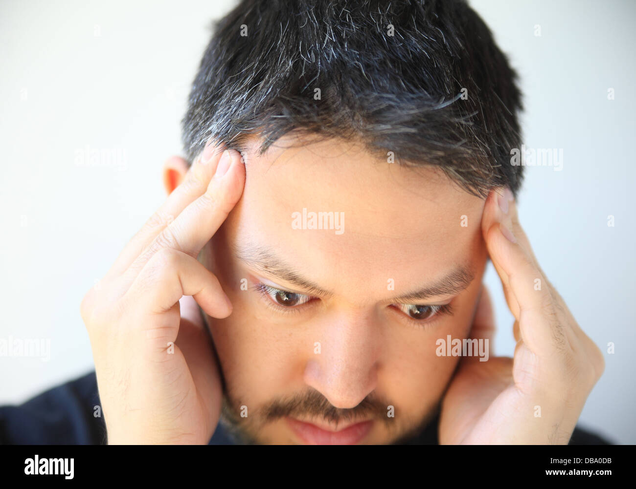 man holds his fingers to his temples Stock Photo