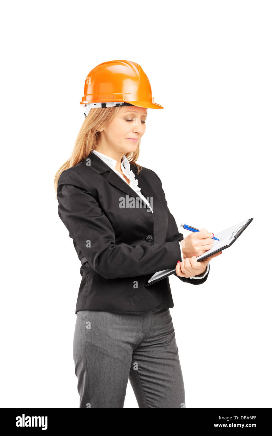 Female architect with a helmet writing on a clipboard Stock Photo