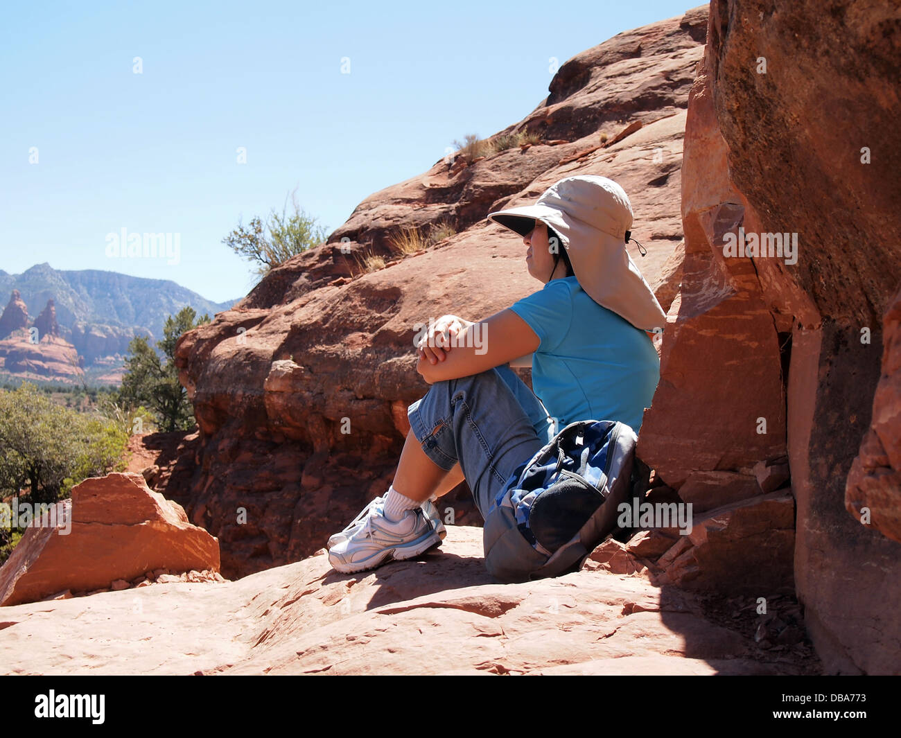 Woman hiker taking a break and enjoying the view from atop Cathedral Rock in Sedona, Arizona, USA Stock Photo