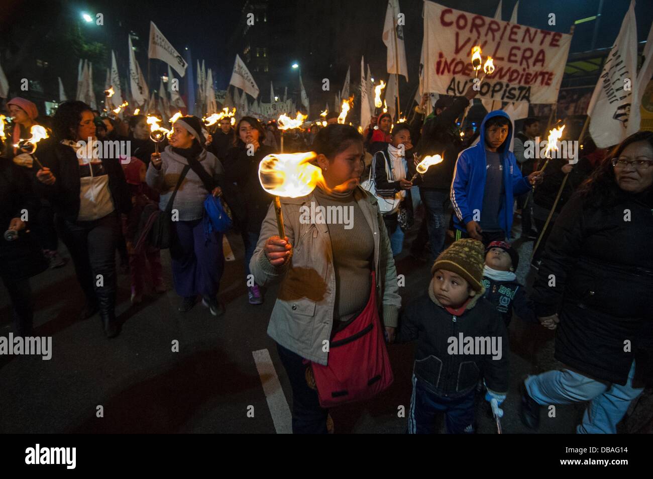 Buenos Aires, Buenos Aires, Argentina. 26th July, 2013. Slumdwellers march with torches from the Obelisco to the Plaza de Mayo as the Second Slumdwellers Congress starts. The demonstrators demand the City and Federal governments solutions to housing problems. Nearly 200.000 people live in slums that lack drinking water, sanitation, gas and other services. Credit:  Patricio Murphy/ZUMAPRESS.com/Alamy Live News Stock Photo