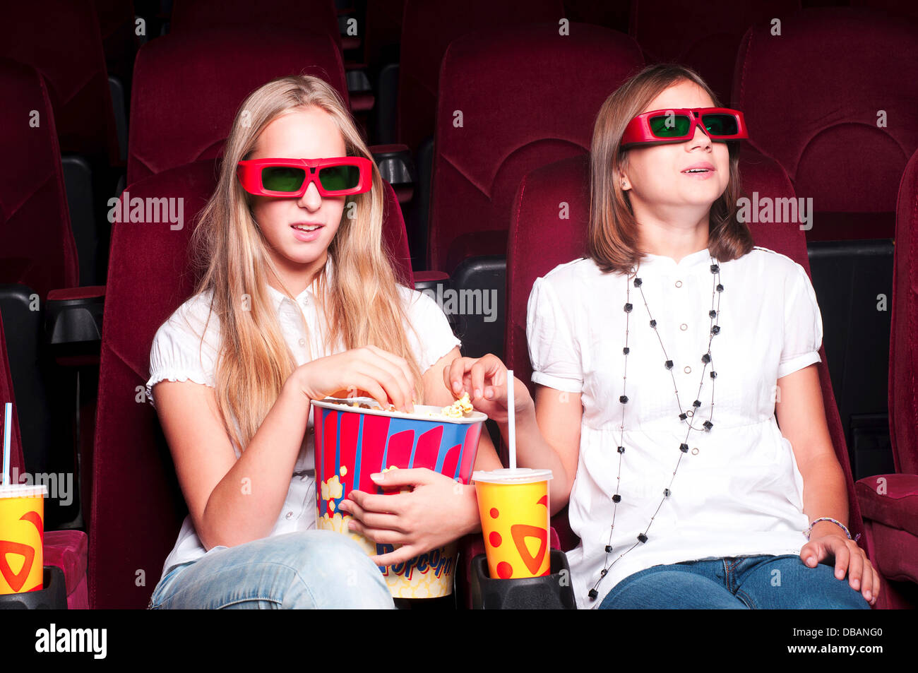two girls watching a movie at the cinema Stock Photo Alamy