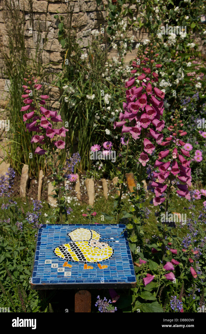 Decorative tile and insect friendly planting in Bugs in Boots garden at RHS Hampton Court Palace Flower Show 2013, London, UK Stock Photo