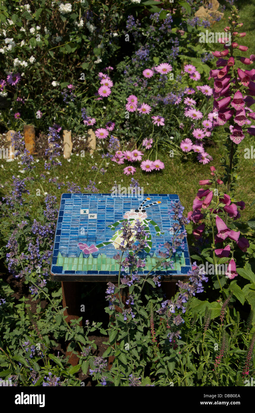 Decorative tile and insect friendly planting in Bugs in Boots garden at RHS Hampton Court Palace Flower Show 2013, London, UK Stock Photo