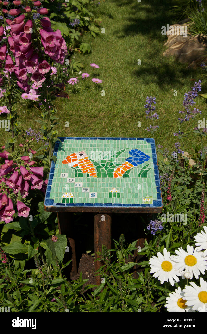 Decorative tile and insect friendly planting in Bugs in Boots garden at RHS Hampton Court Palace Flower Show 2013, London, UK Stock Photo