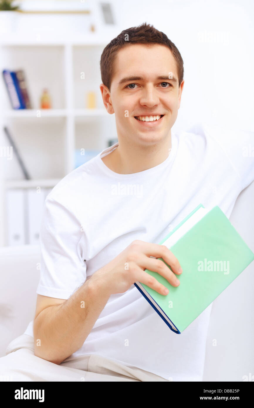 Young man at home with a book Stock Photo - Alamy