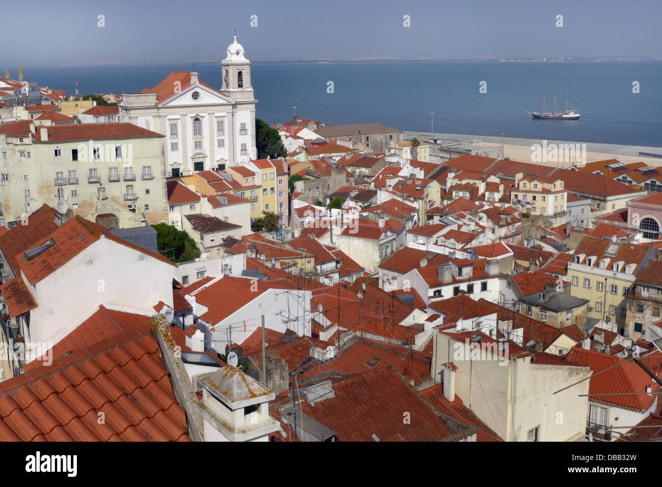 A view of the Alfama district of Lisbon form the Portas do Sol with the church of Sao Estevao and the Tagus river. Stock Photo