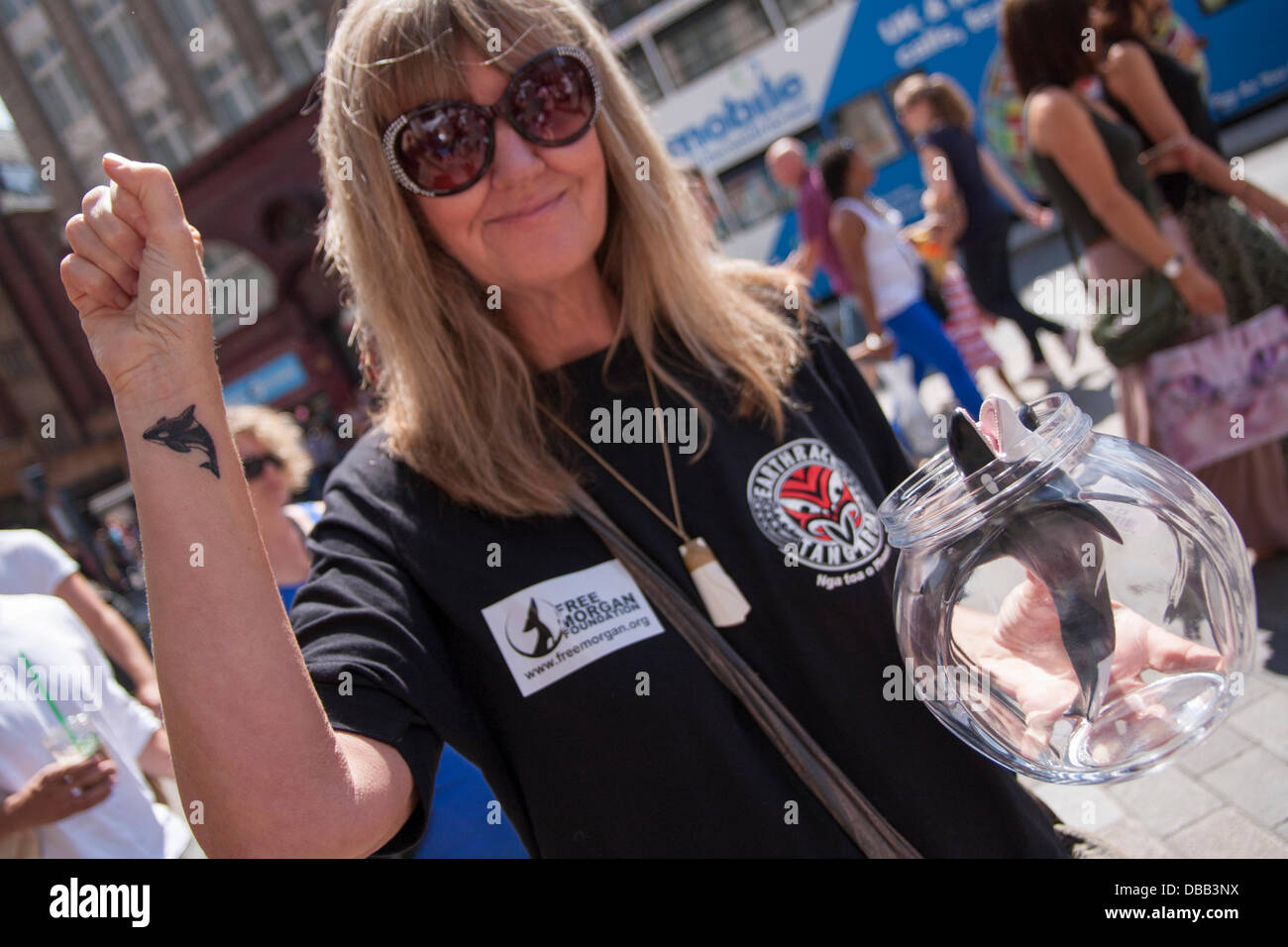 London, UK. 27th July 2013. A woman with her captive toy Orca as protesters in London and around the world demonstrate against marine mamals held captive for entertainment. Credit:  Paul Davey/Alamy Live News Stock Photo