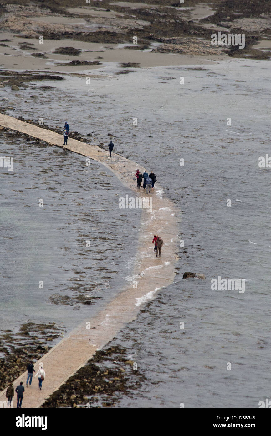 Pedestrians cross footpath to Saint Michael's Mount Cornwall as the tide comes in Stock Photo