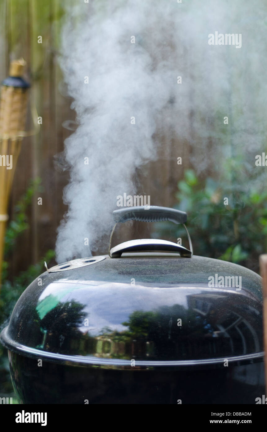 A kettle style barbecue smoking Stock Photo