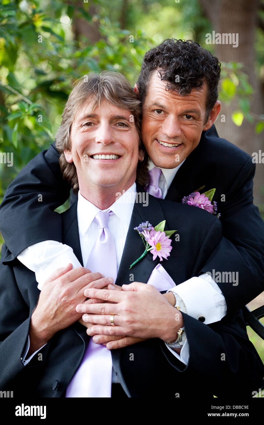 Handsome gay couple in love, posing for an outdoor wedding portrait.  Stock Photo