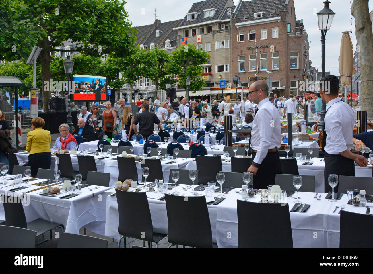 Maastricht assorted restaurant bars along Vrijthof Square pavement prepared tables await ticket holders for André Rieu outdoor evening music concert Stock Photo