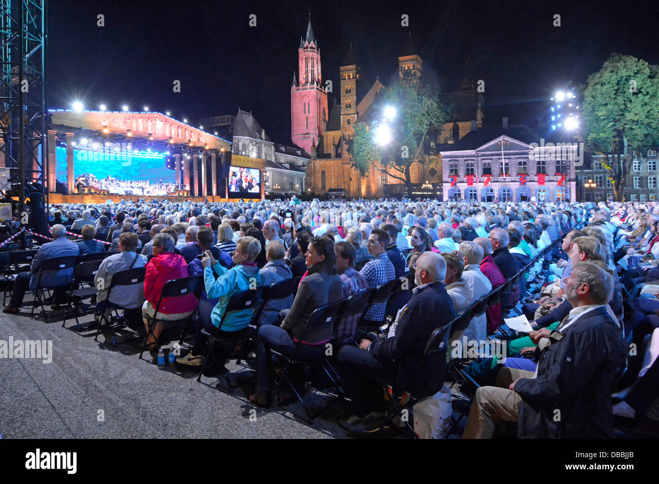 Maastricht Vrijthof Square Limburg close up paying audience watching & listening to André Rieu evening music concert event floodlit trees & buildings Stock Photo