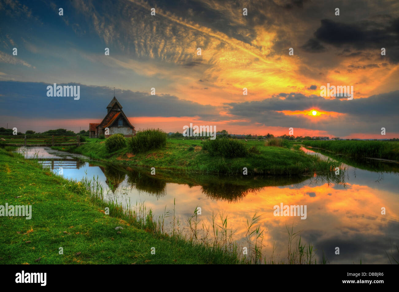 Church sunset reflections. St Thomas a Becket, the isolated church, in Romney Marsh, Kent, SE England, UK Stock Photo