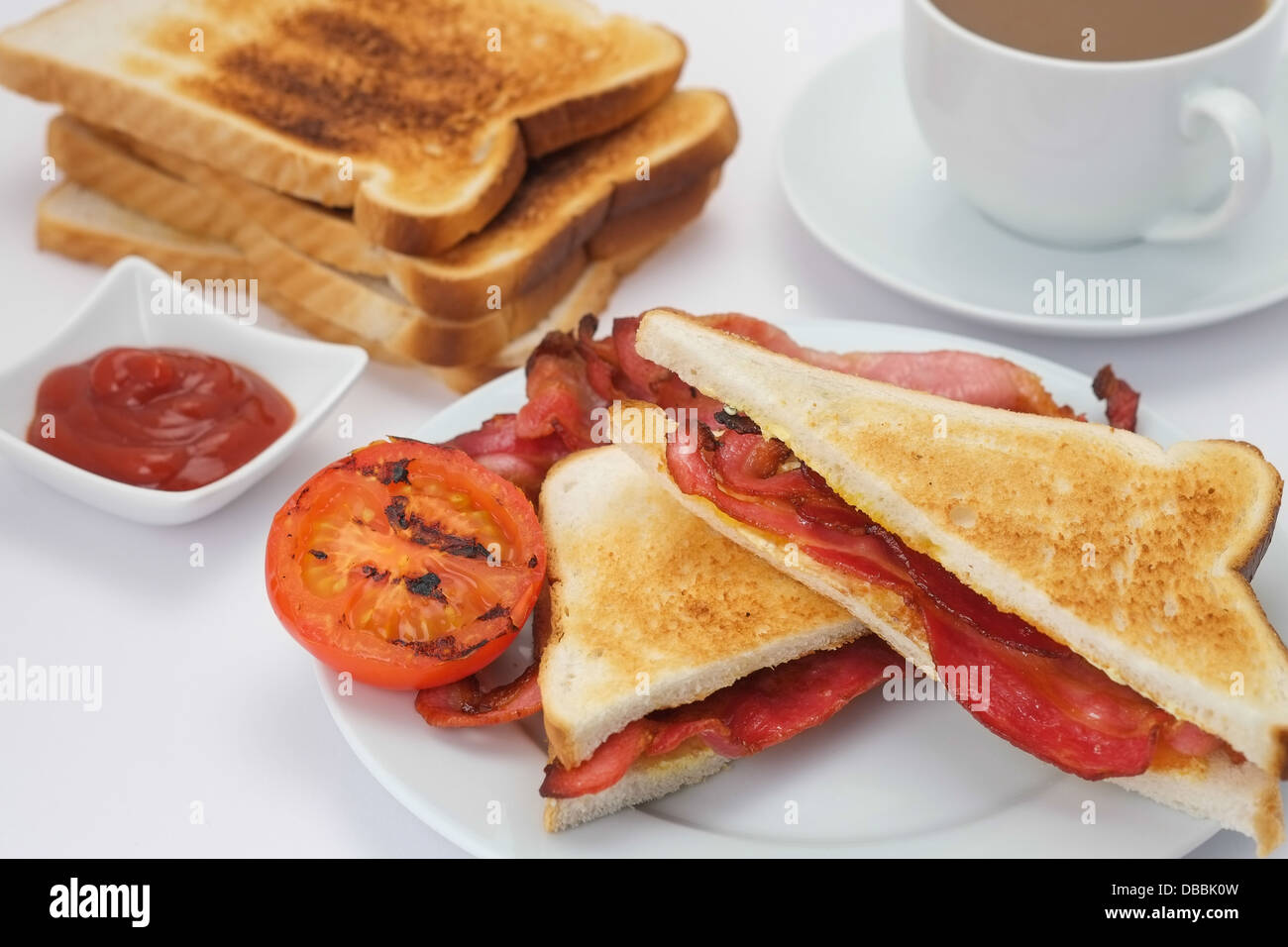 Breakfast of a bacon sandwich with toast and a cup of coffee Stock Photo