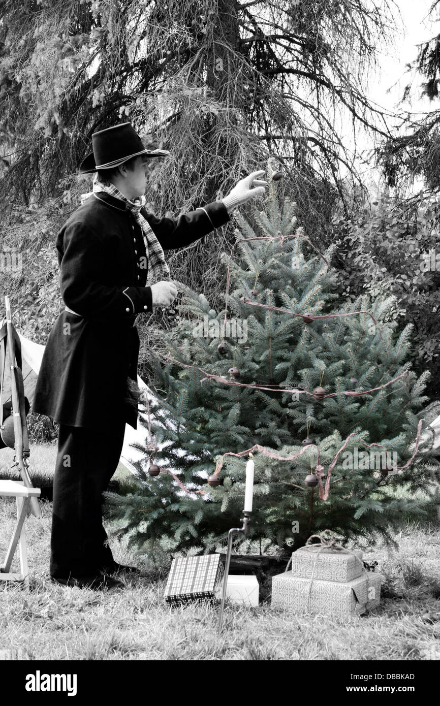 A young Civil War soldier reenactor at Christmas time decorating a