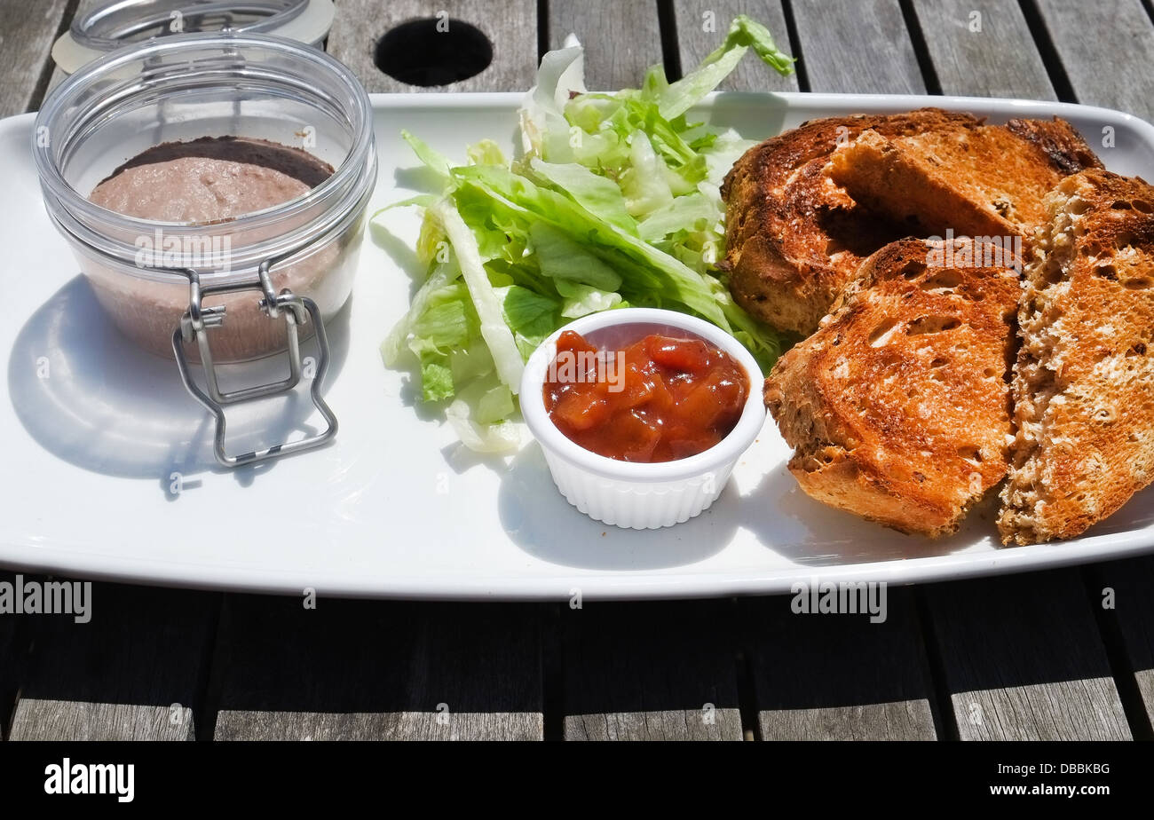 Pot of chicken liver pate with lettuce, chutney and toasted granary bread - served as a pub lunch in UK Stock Photo