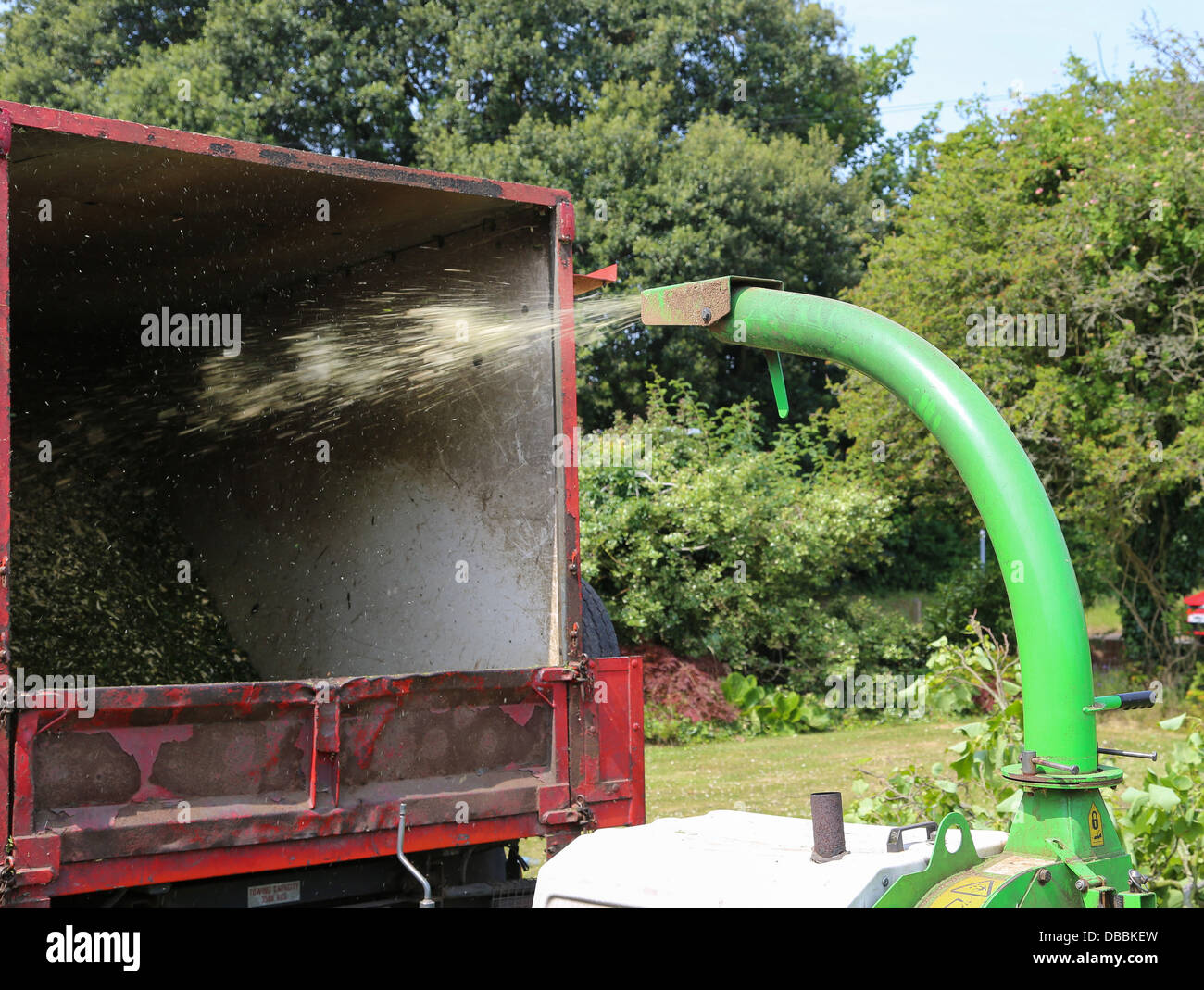 https://c8.alamy.com/comp/DBBKEW/a-wood-chipper-machine-spraying-chopped-up-leaves-and-wood-chips-into-DBBKEW.jpg