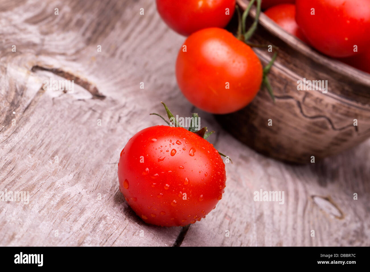 Cherry tomatoes on wooden table with water drops Stock Photo - Alamy