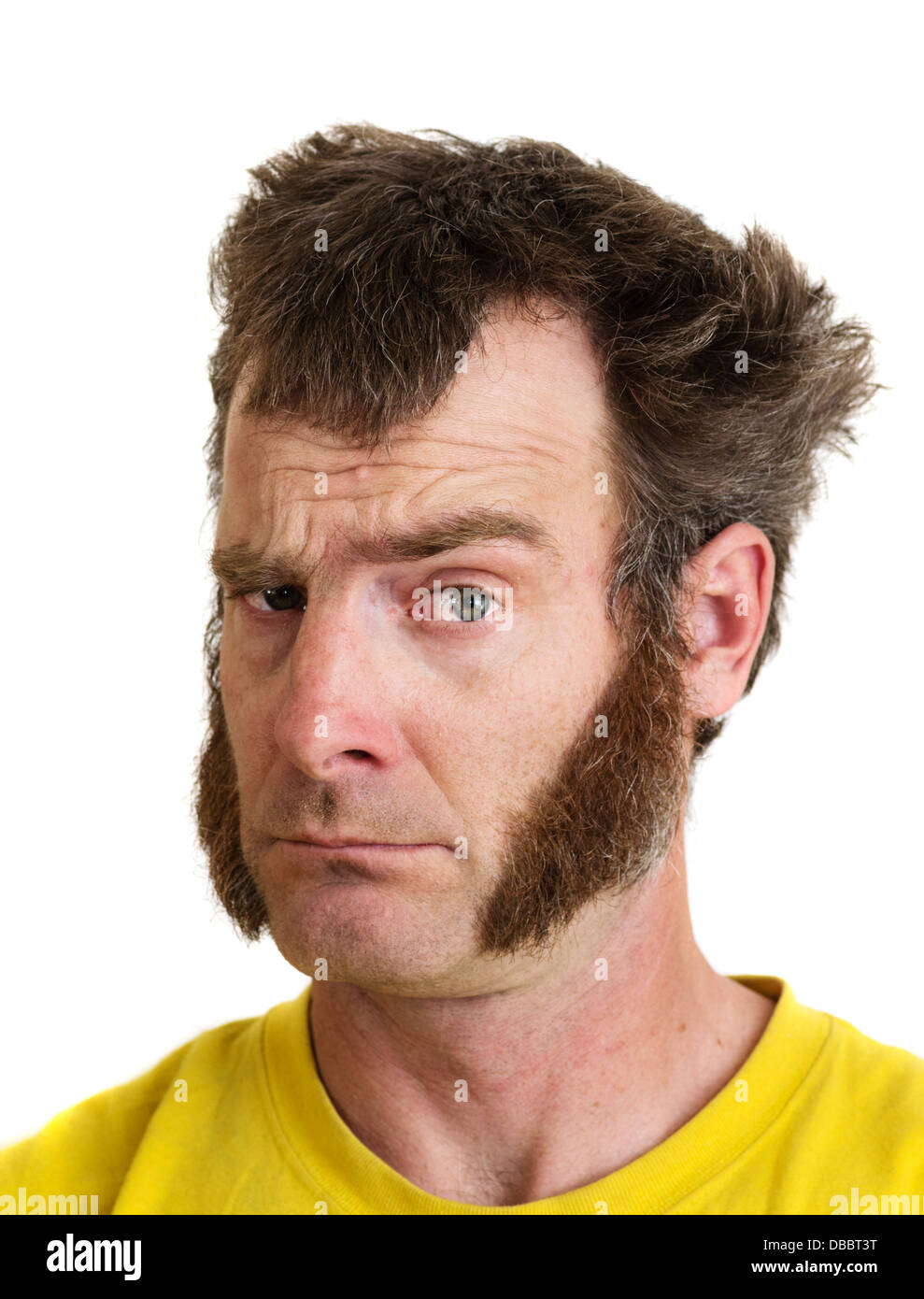 a man with large sideburns looks at the camera with one eyebrow raised Stock Photo
