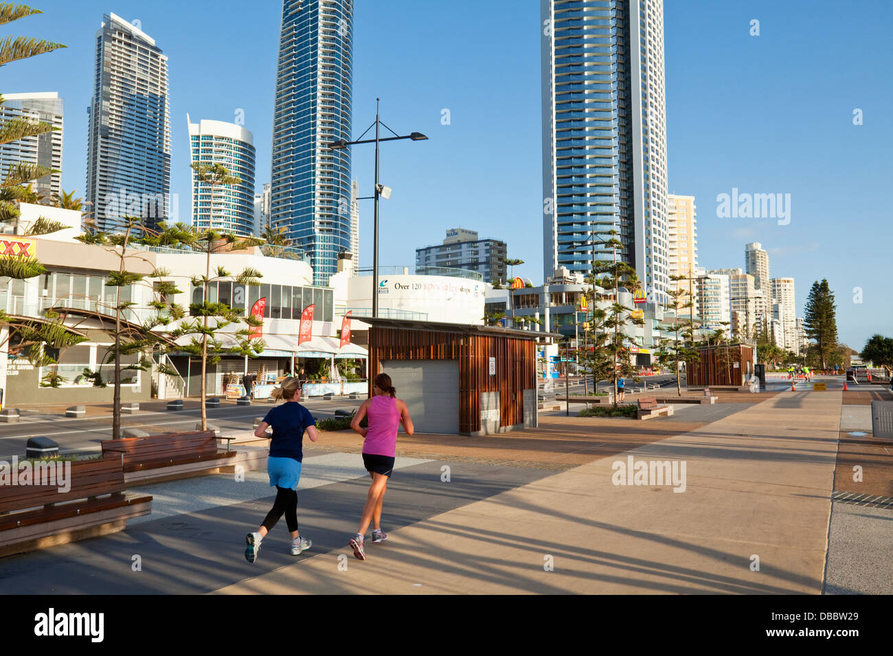 Women jogging along promenade at dawn. Surfers Paradise, Gold Coast, Queensland, Australia Stock Photo