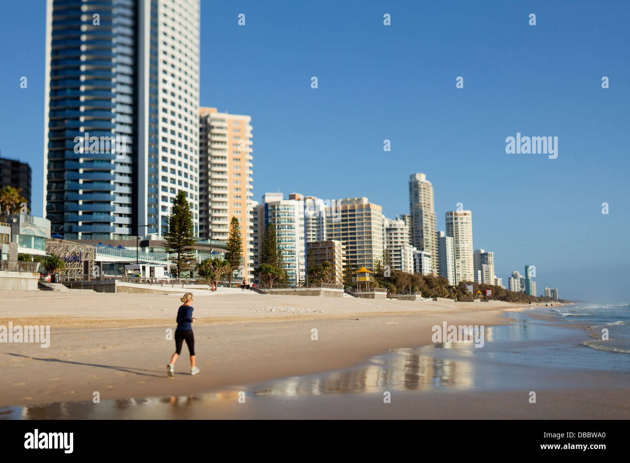 Jogger on beach and city skyline at Surfers Paradise. Gold Coast, Queensland, Australia Stock Photo