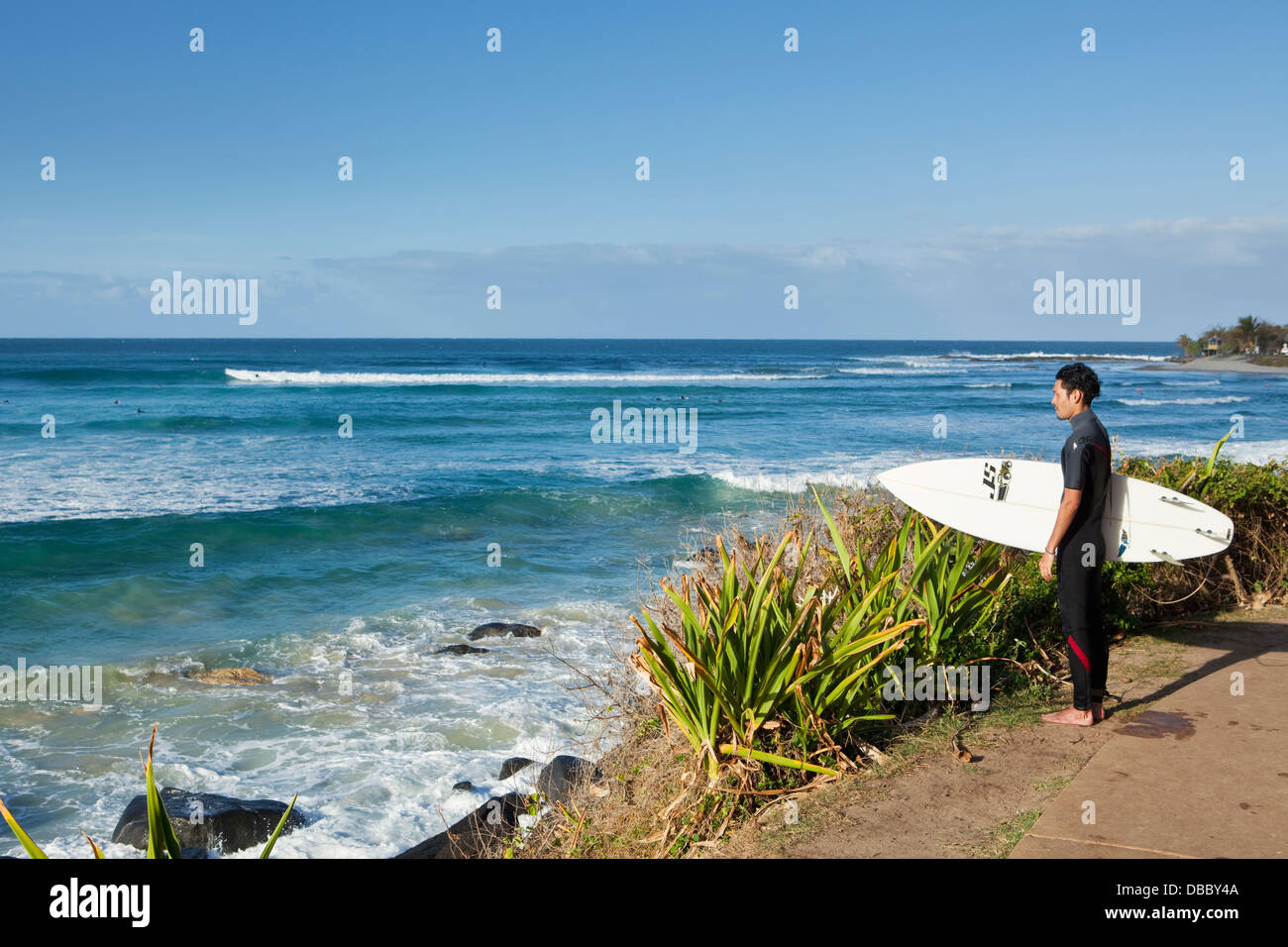 Surfer looking out to the waves at Greenmount Beach. Coolangatta, Gold Coast, Queensland