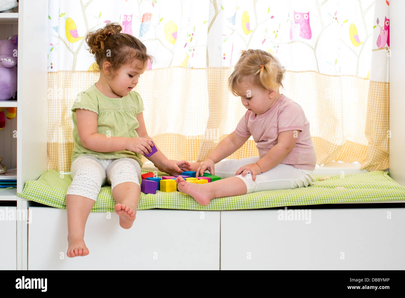 children sisters play together indoors Stock Photo