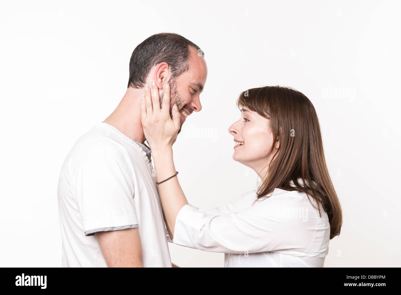 Loving adult couple looking at each other, woman holding man's face