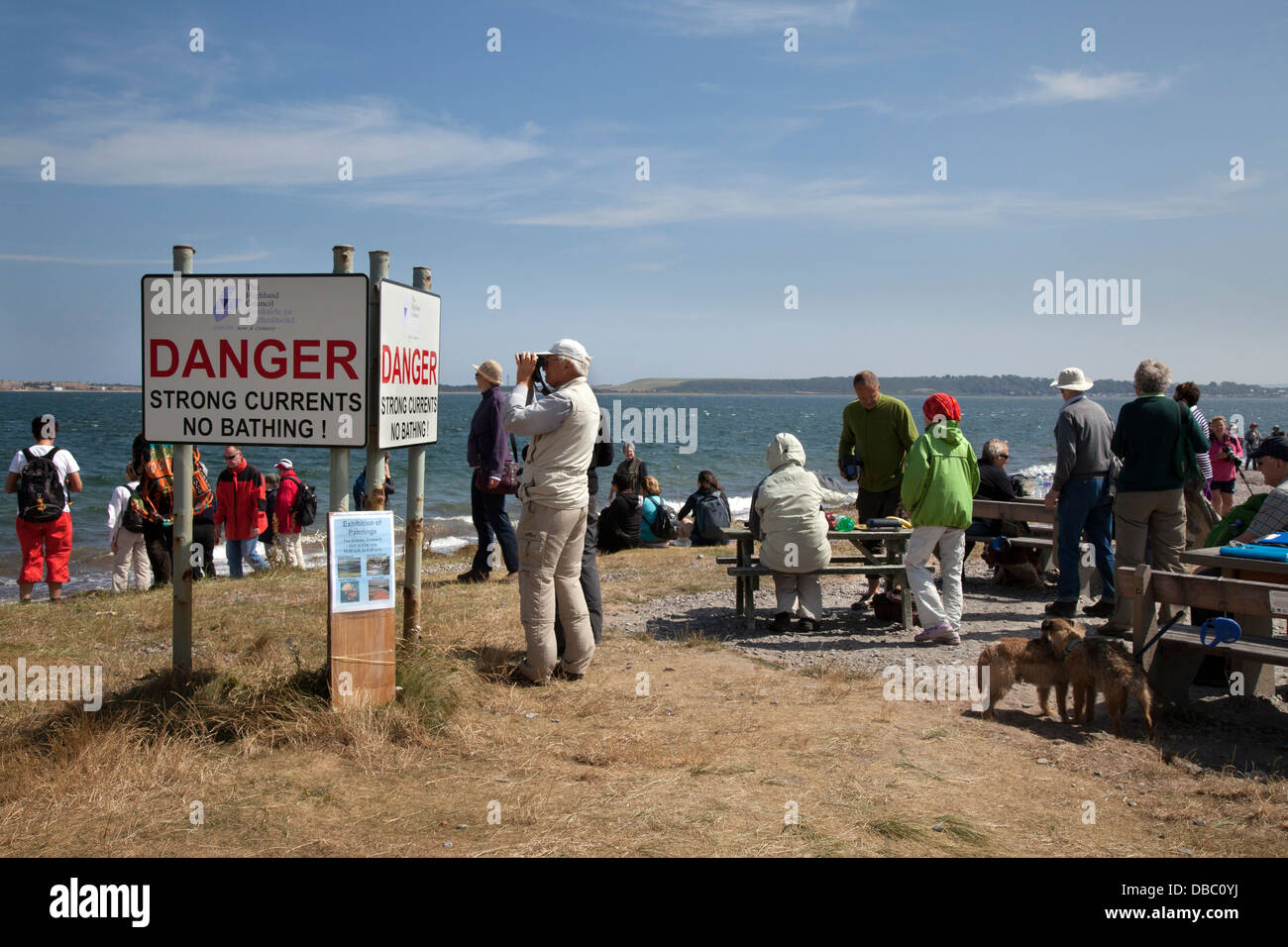 Dolphin watchers looking out to sea at Chanonry Point, Tourists watching the Moray Firth, Bottlenose dolphins, Cromarty, Black isle, Scotland, UK Stock Photo