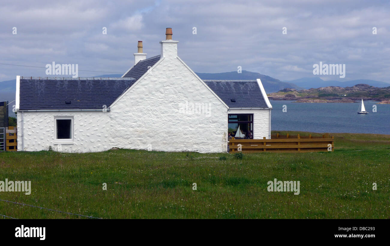 Whitewashed cottage on the Island of Iona Scotland overlooking the Sound of Iona towards the coast of Mull Stock Photo