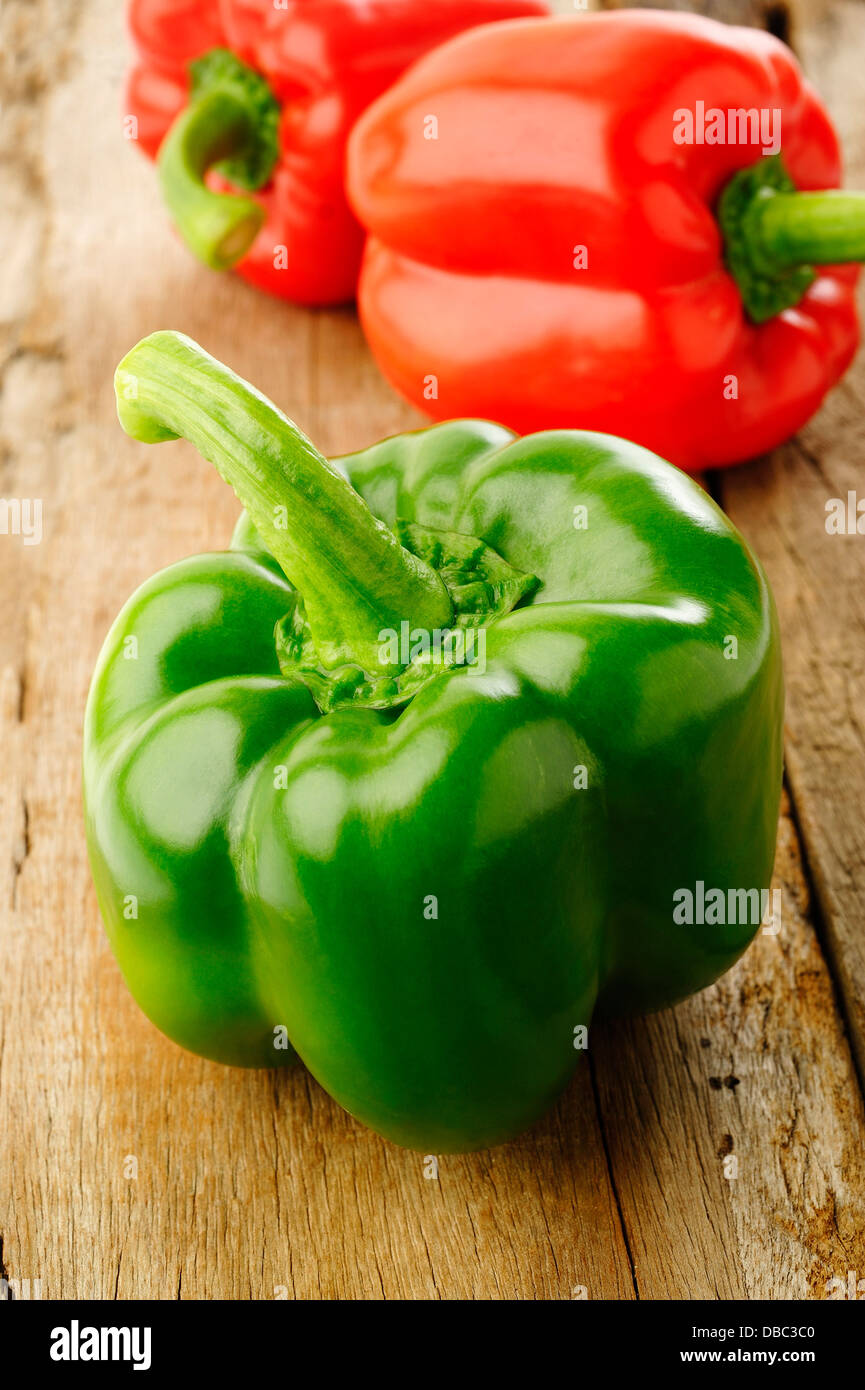 Colored bell peppers on wooden table background Stock Photo - Alamy