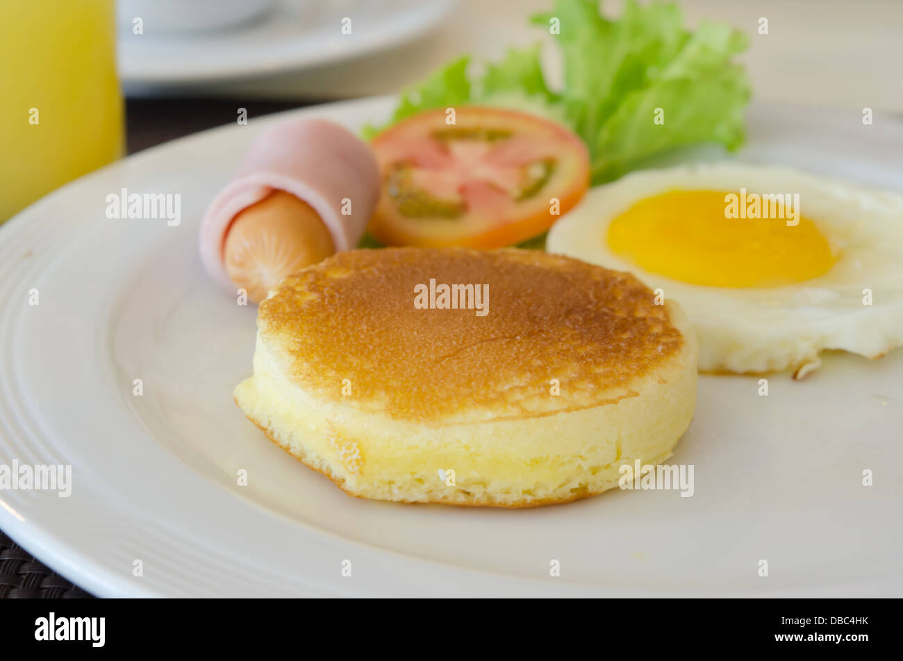 pancake , fried egg , ham and sausage , fresh vegetable . Stock Photo