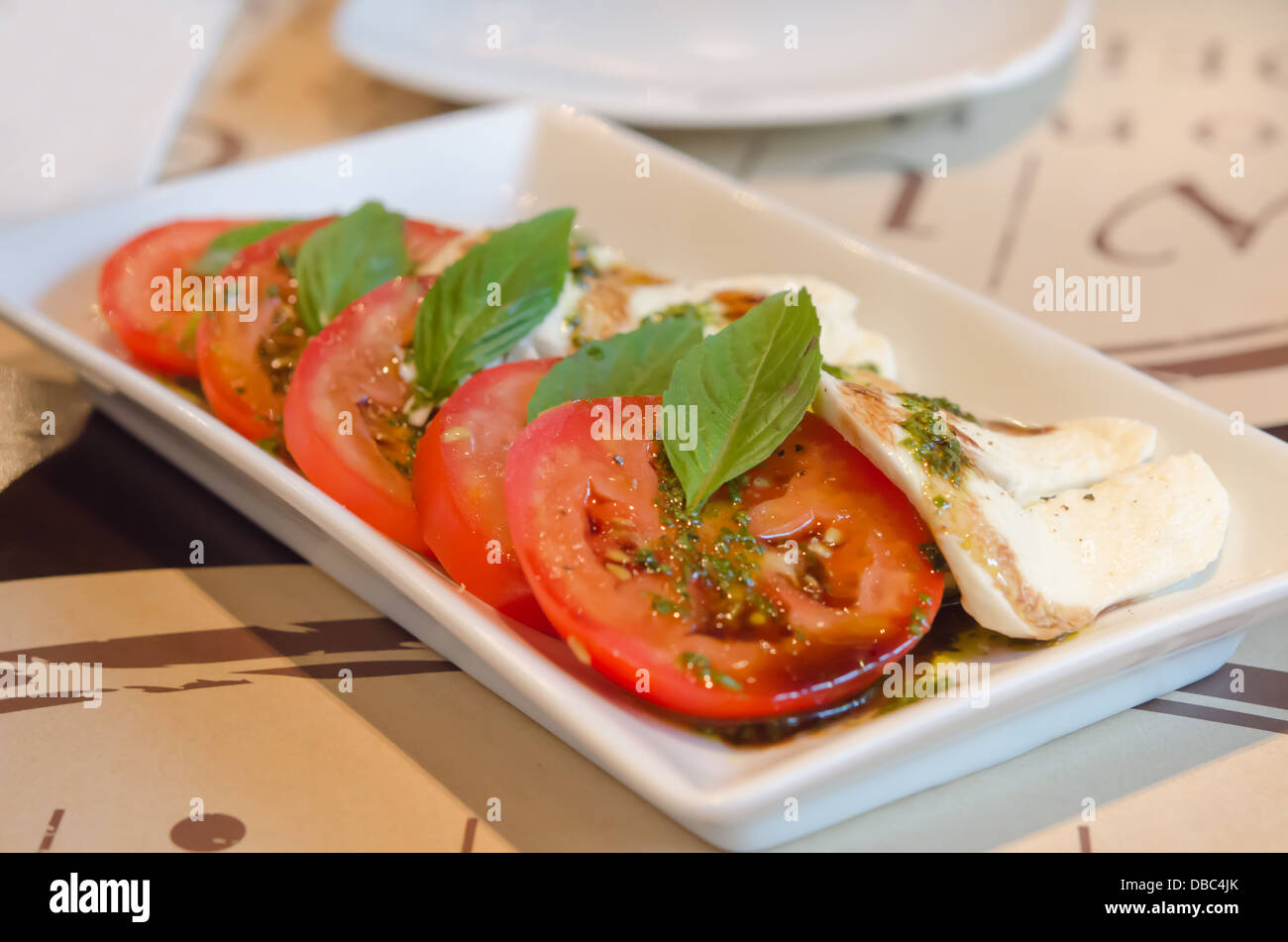 slice red tomato and mushroom with basil and delicious sauce on white plate Stock Photo