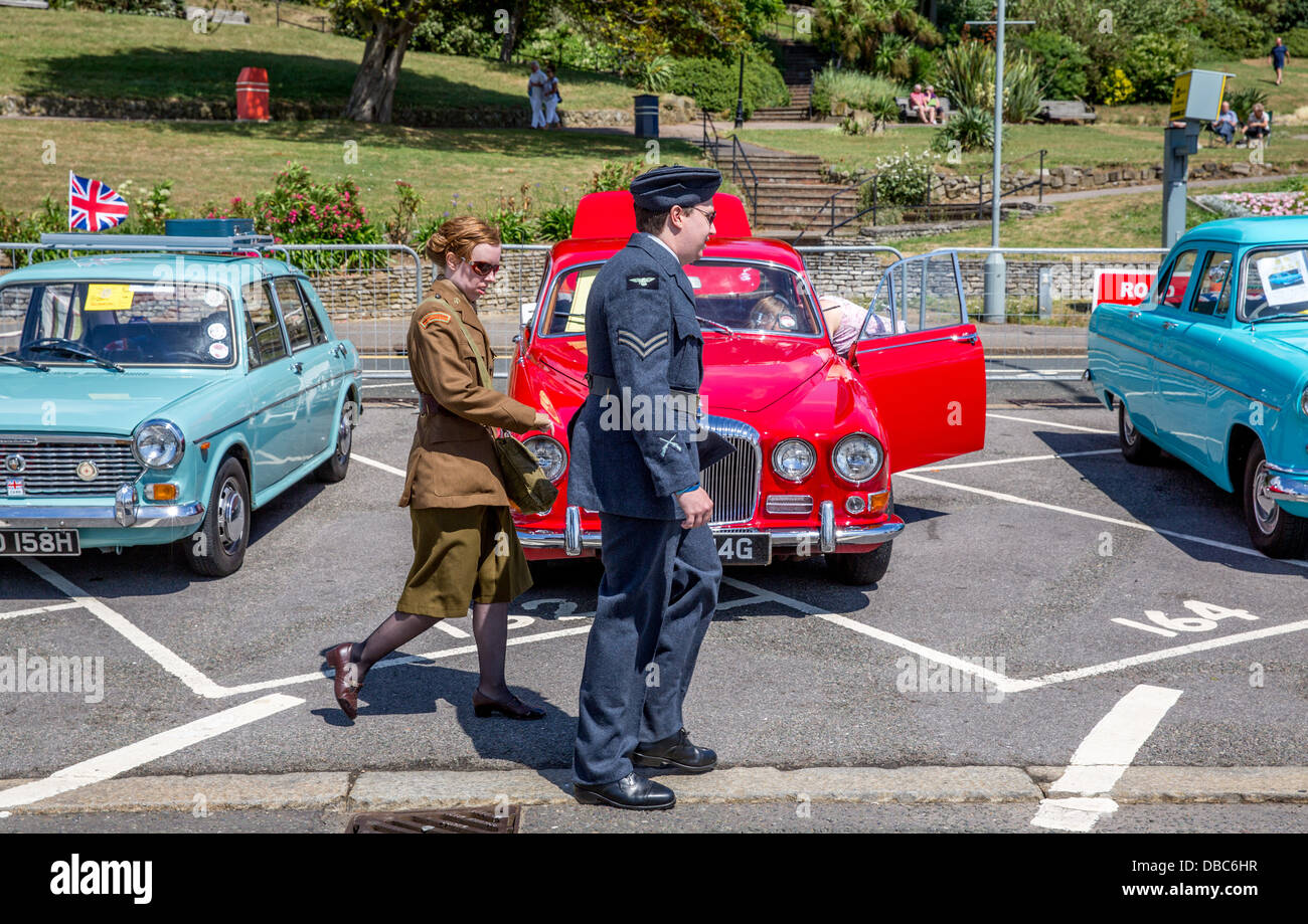 28/07/2013 couple dressed in british war time uniforms walk past Daimler and Austin 1100, London to Southend Classic car run Stock Photo