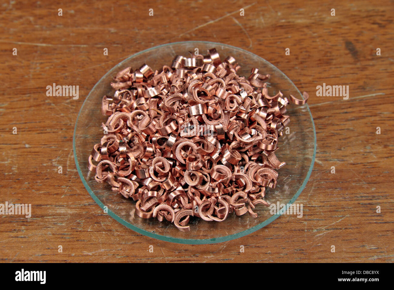 A watch glass containing copper (Cu) shavings/turnings, as used in a UK high school. Stock Photo