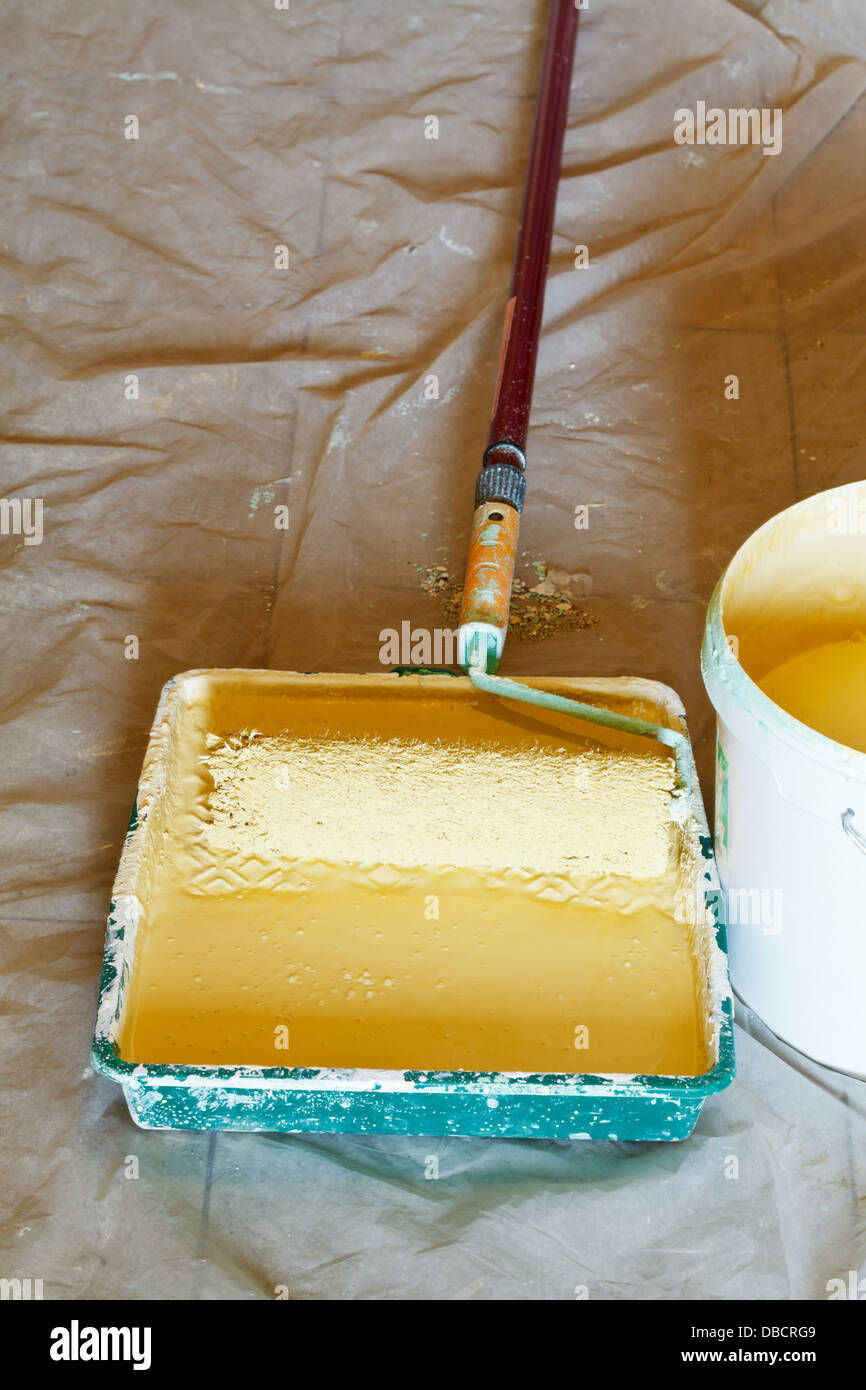 plastic paint tray with yellow emulsion paint and painter roller brush Stock Photo Alamy