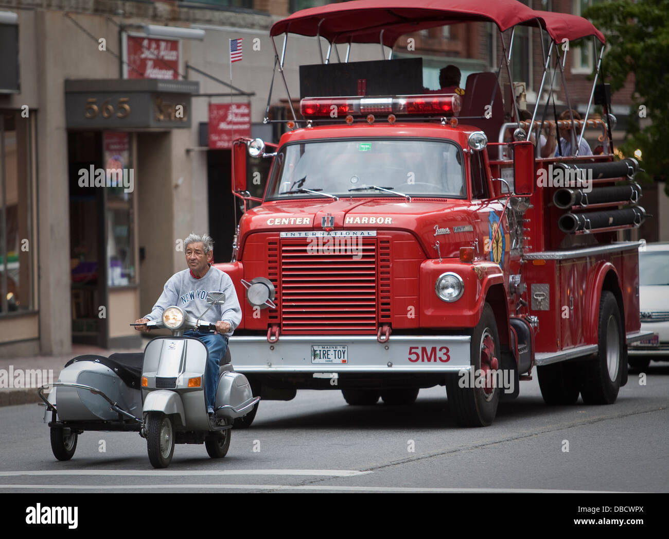 A firetruck converted into a tourist bus and a moped with a sidecar are pictured in Portland, Maine Stock Photo