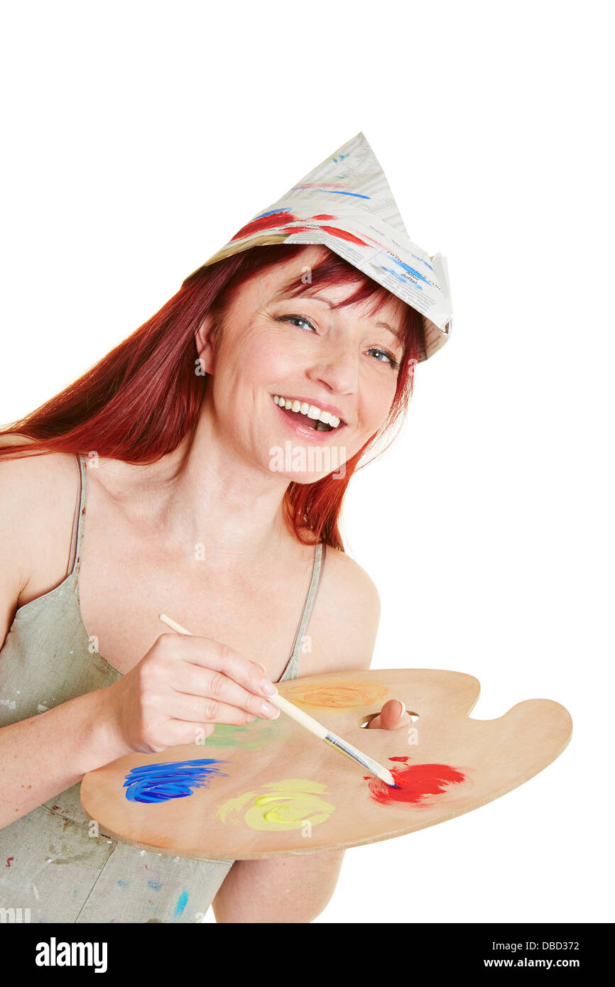 Happy woman working with brush, mixing palette and painter hat Stock Photo