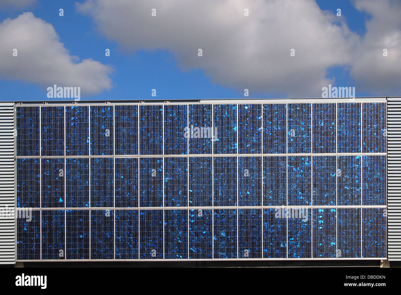 Solar Panel sunlit with blue sky and white clouds Stock Photo