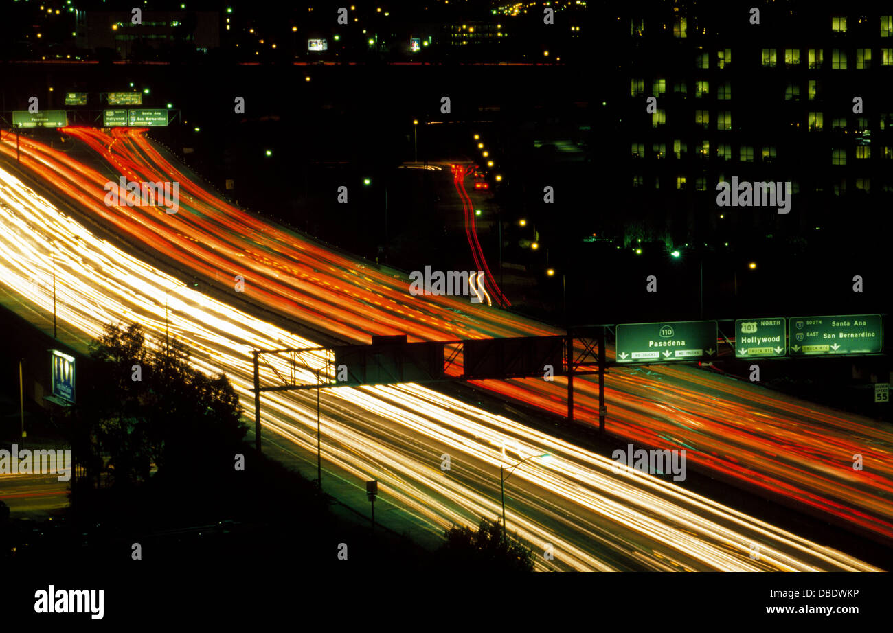 Streaks of white from headlights and red from taillights flow from vehicles speeding in the night along the busy freeways of Los Angeles, California. Stock Photo