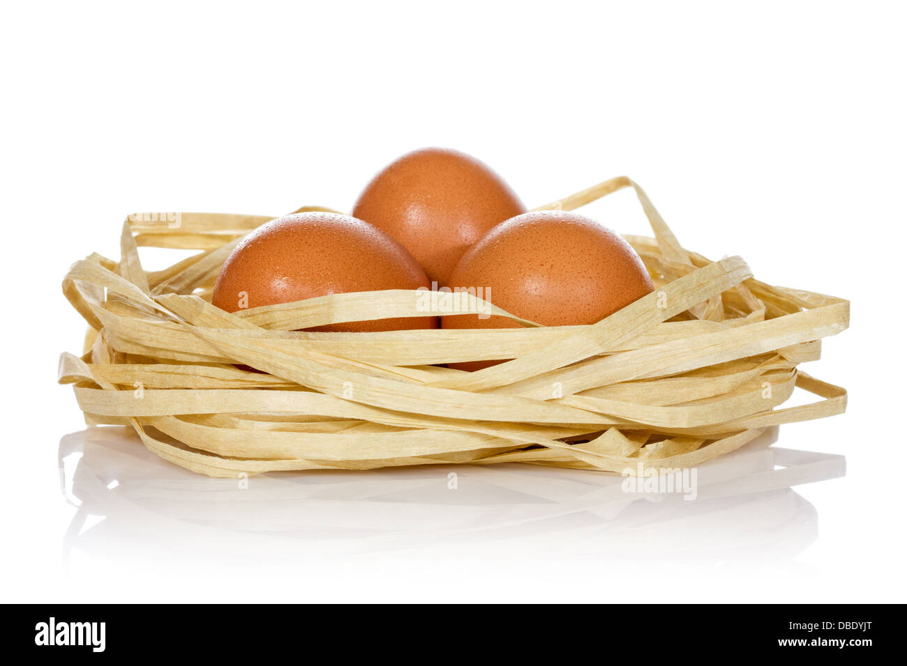 Three eggs in the nest over a white background Stock Photo - Alamy