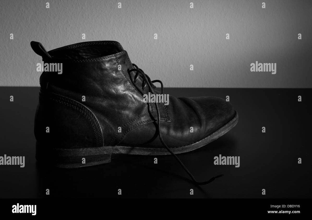 A black and white photo of Italian leather shoe on a black table Stock Photo