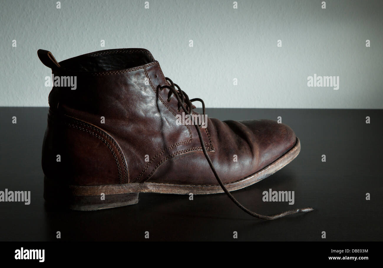 A photo of italian leather shoe on a black table. It is well worn because it is a much loved fashion item. Stock Photo