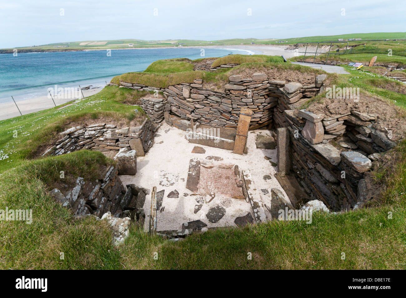 House 1 at Skara Brae Neolithic Village on Mainland Orkney with the Bay of Skaill in the background. Stock Photo