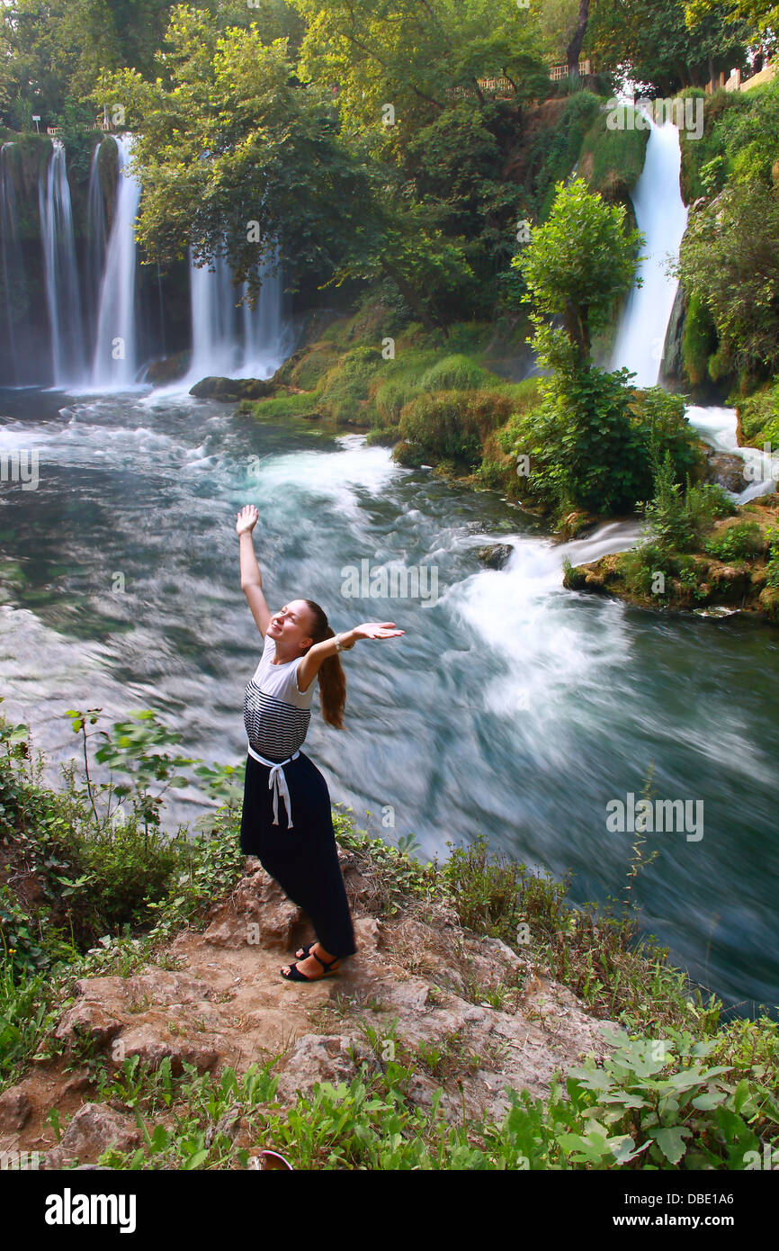 girl in waterfall enjoying life with mountain and waterfall view Stock Photo