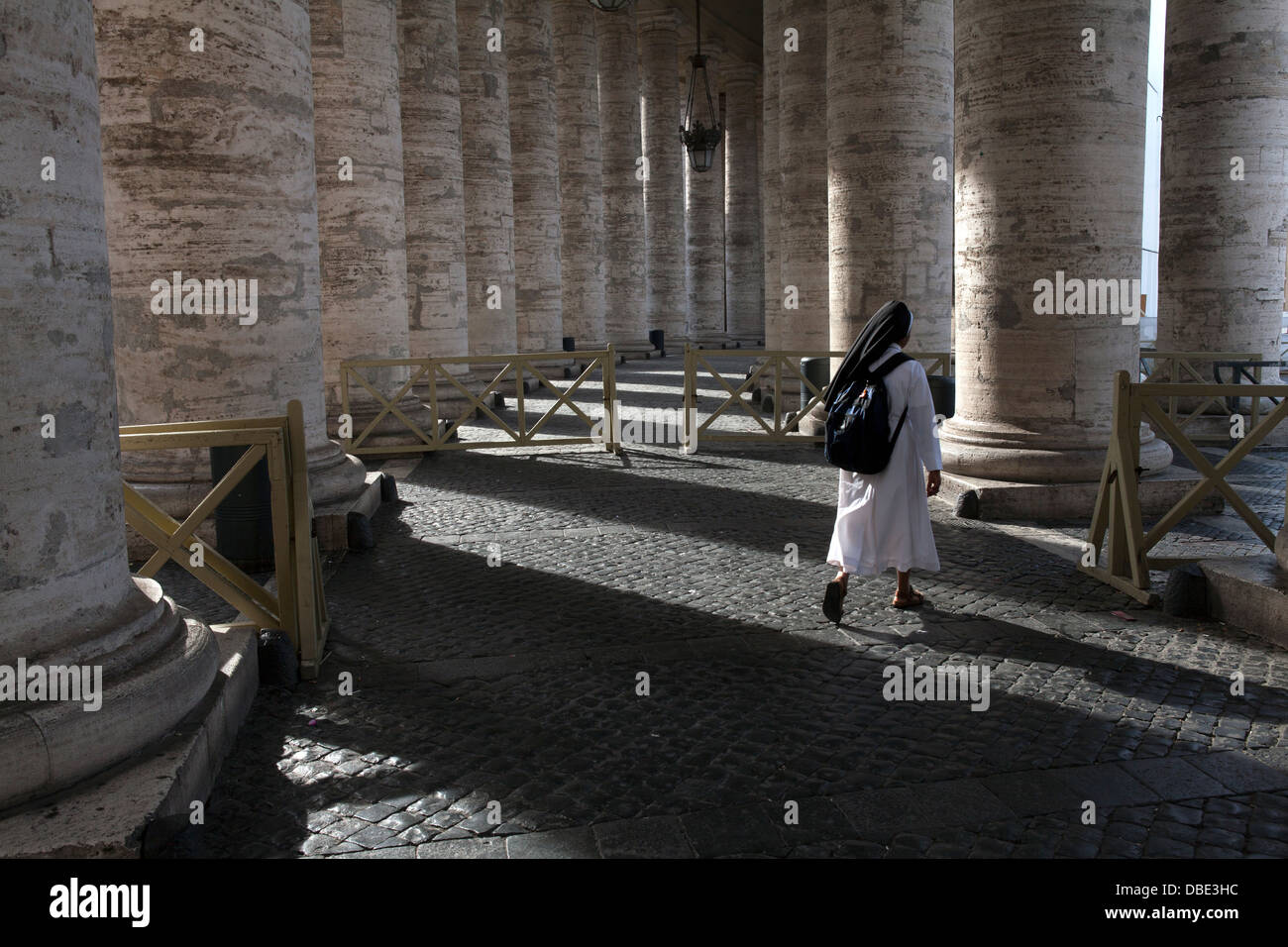 A nuns through Bernini's colonnade in St. Peter's Square at the Vatican, Rome Stock Photo