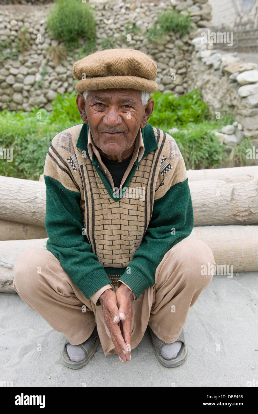 Squatting man wearing traditional Hunza Valley hat, Karimabad, Hunza Valley, Gilgit-Baltistan, Pakistan Stock Photo