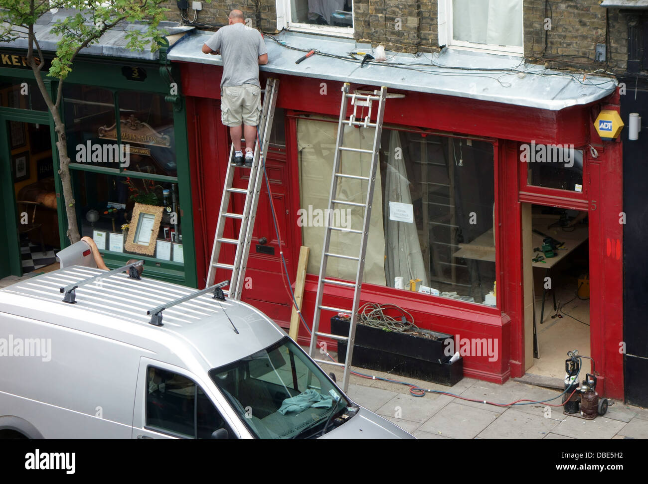 Builder works on refurbishing empty shop, Islington, London Stock Photo